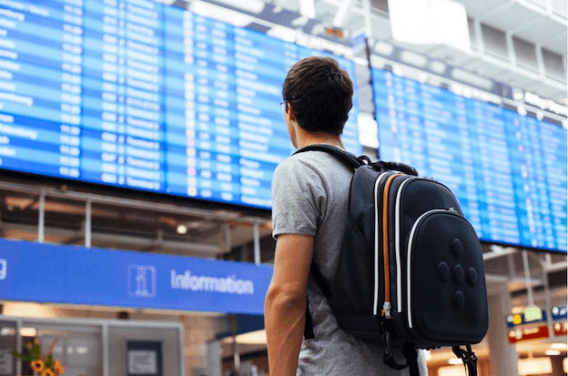 high school student standing in an airport ready to study abroad