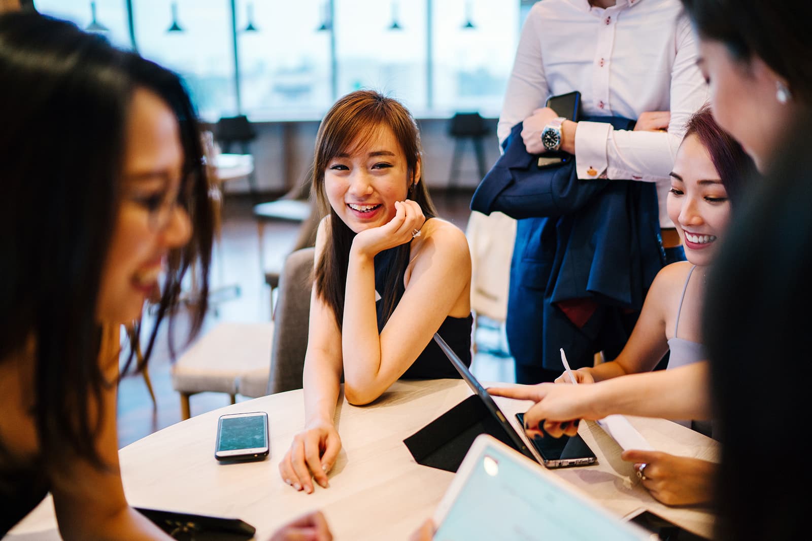 Group of students sitting around a table talking during an extracurricular activity.