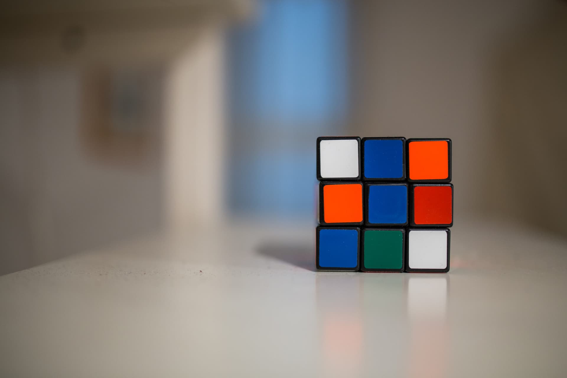 Unsolved Rubix cube sitting on a table. Learning how to solve a Rubix cube can teach you how to improve problem solving skills.