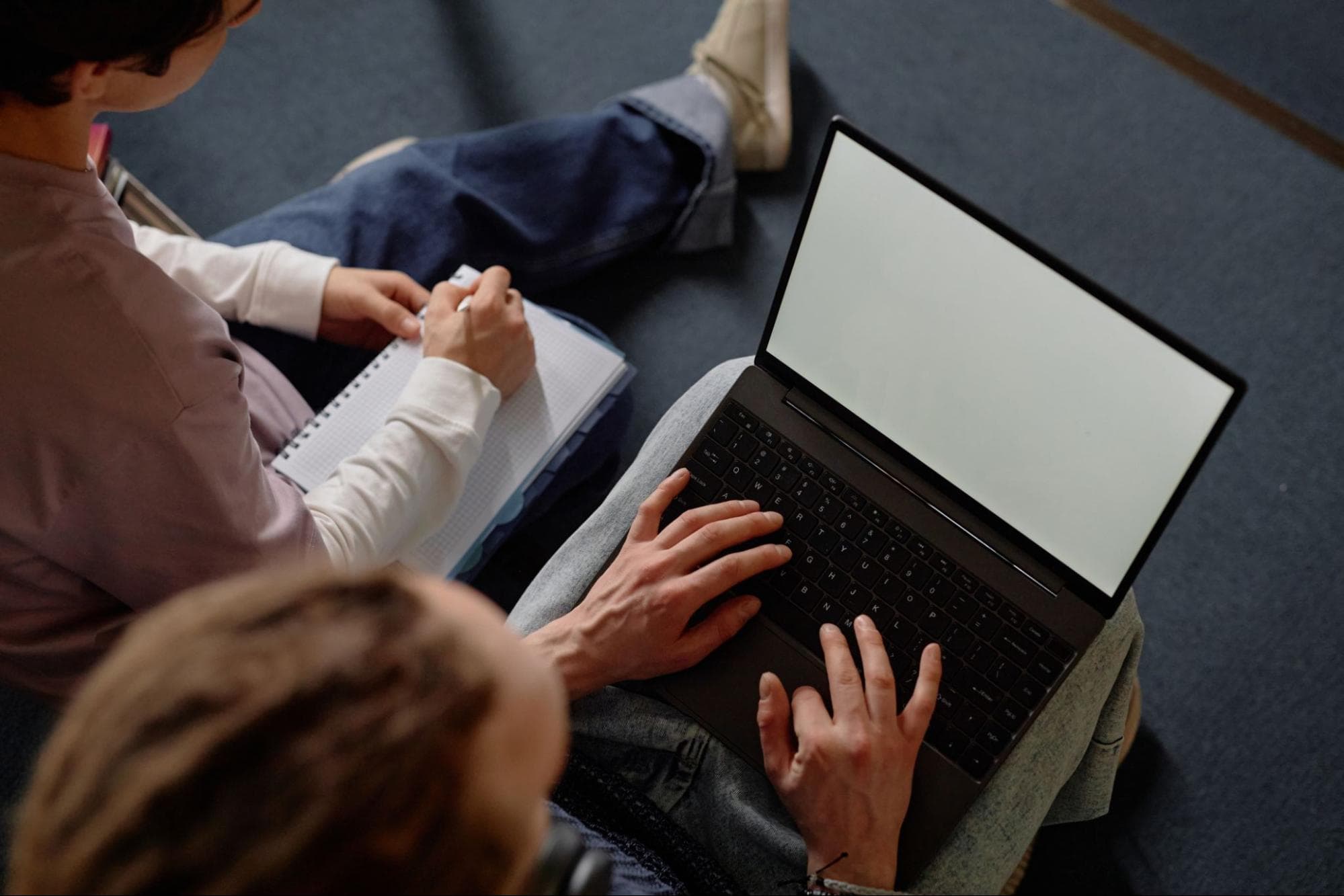 Two students look for college essay help online.